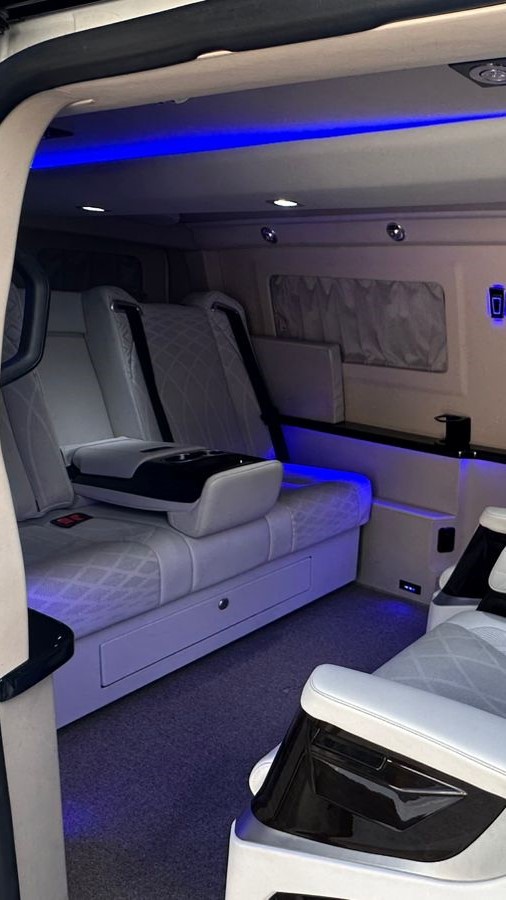 Cabine da mini van executiva com sofá e iluminação azul